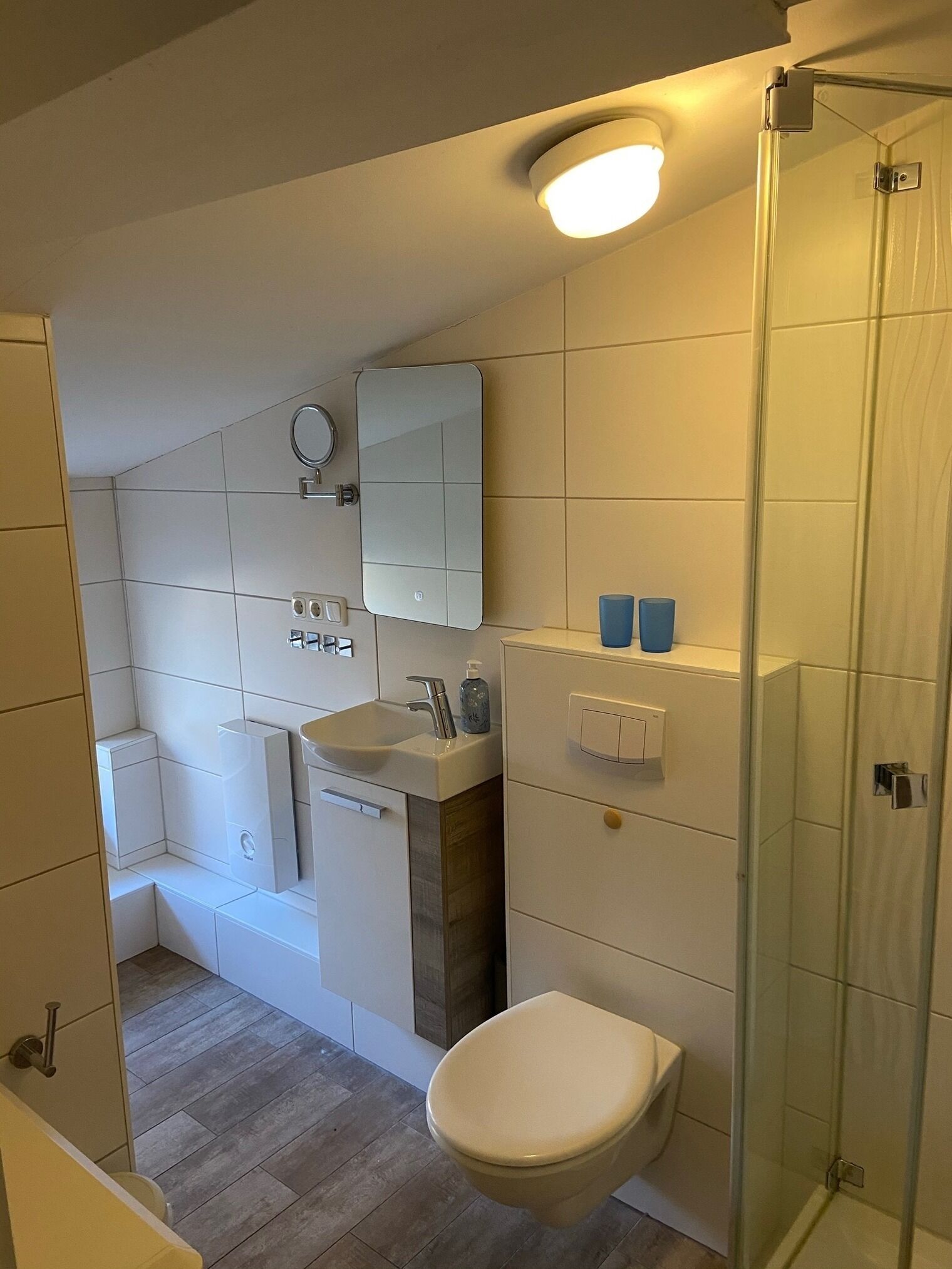 Une salle de bain moderne équipée de toilettes, d’un lavabo et d’une douche à parois de verre.