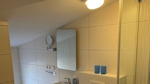 Une salle de bain moderne équipée de toilettes, d’un lavabo et d’une douche à parois de verre.