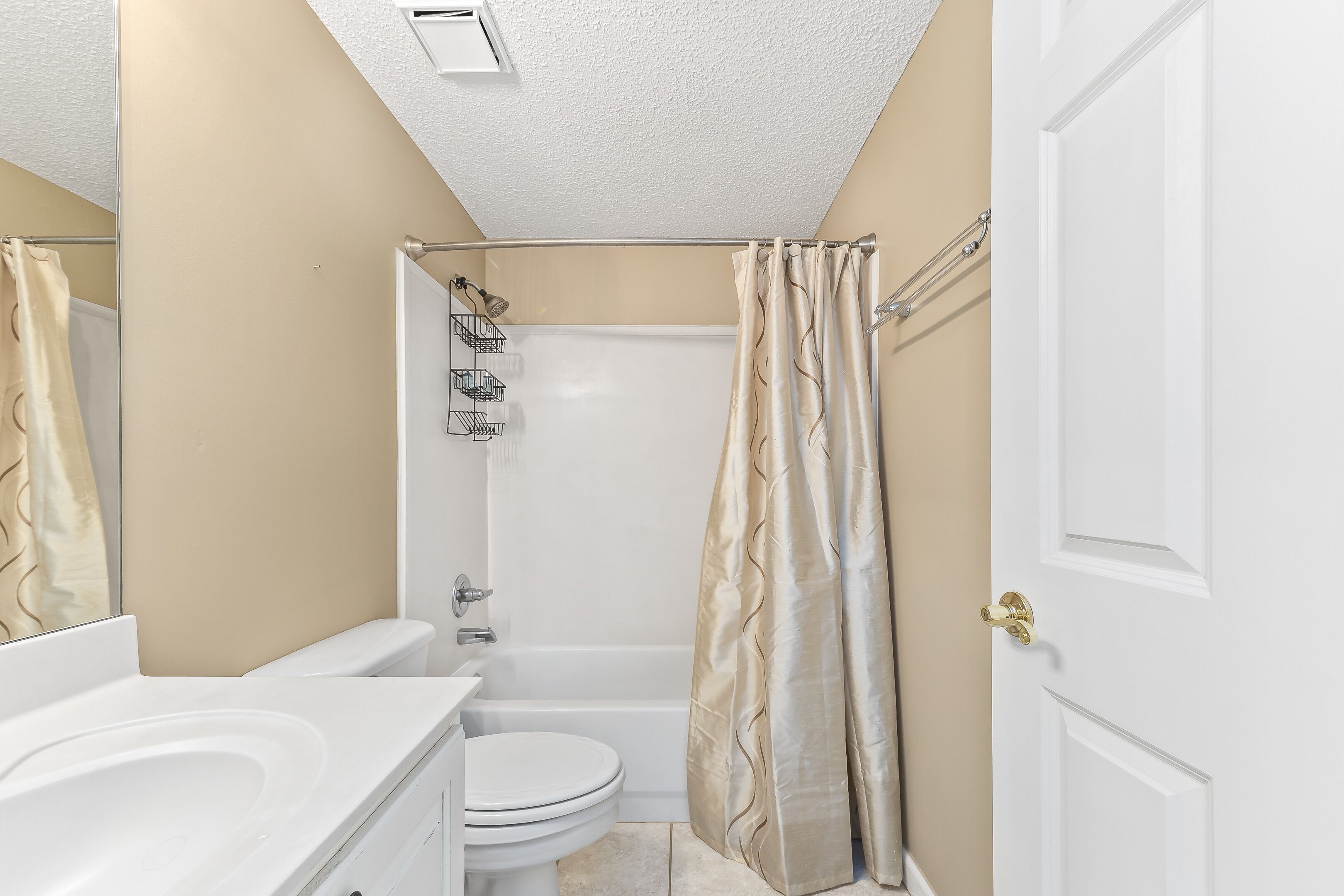 A bathroom with a bathtub, toilet, and sink.