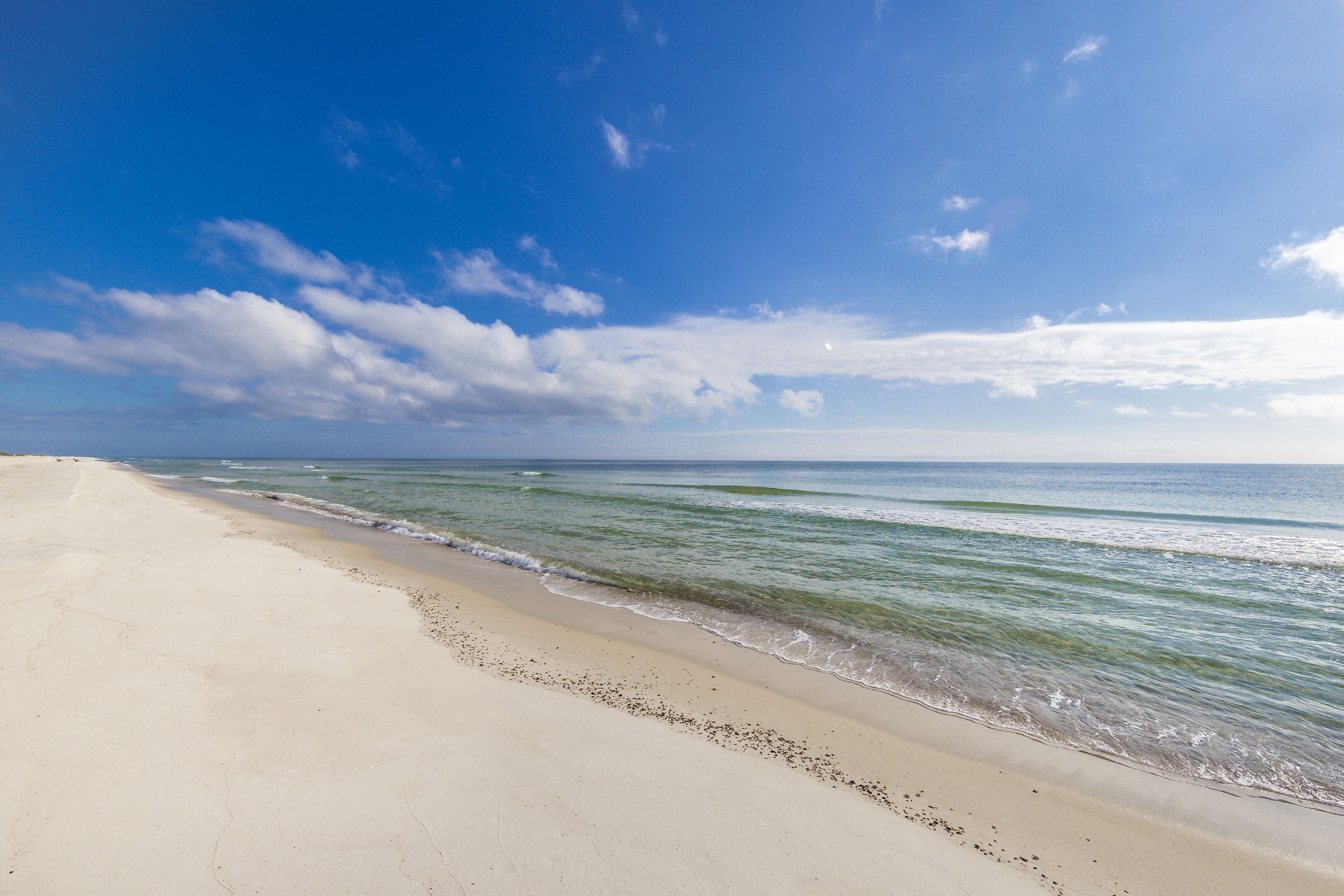 A beach with a clear sky and calm sea.