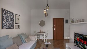 Ett modernt vardagsrum med en soffa, ett soffbord, en tv och en matplats.