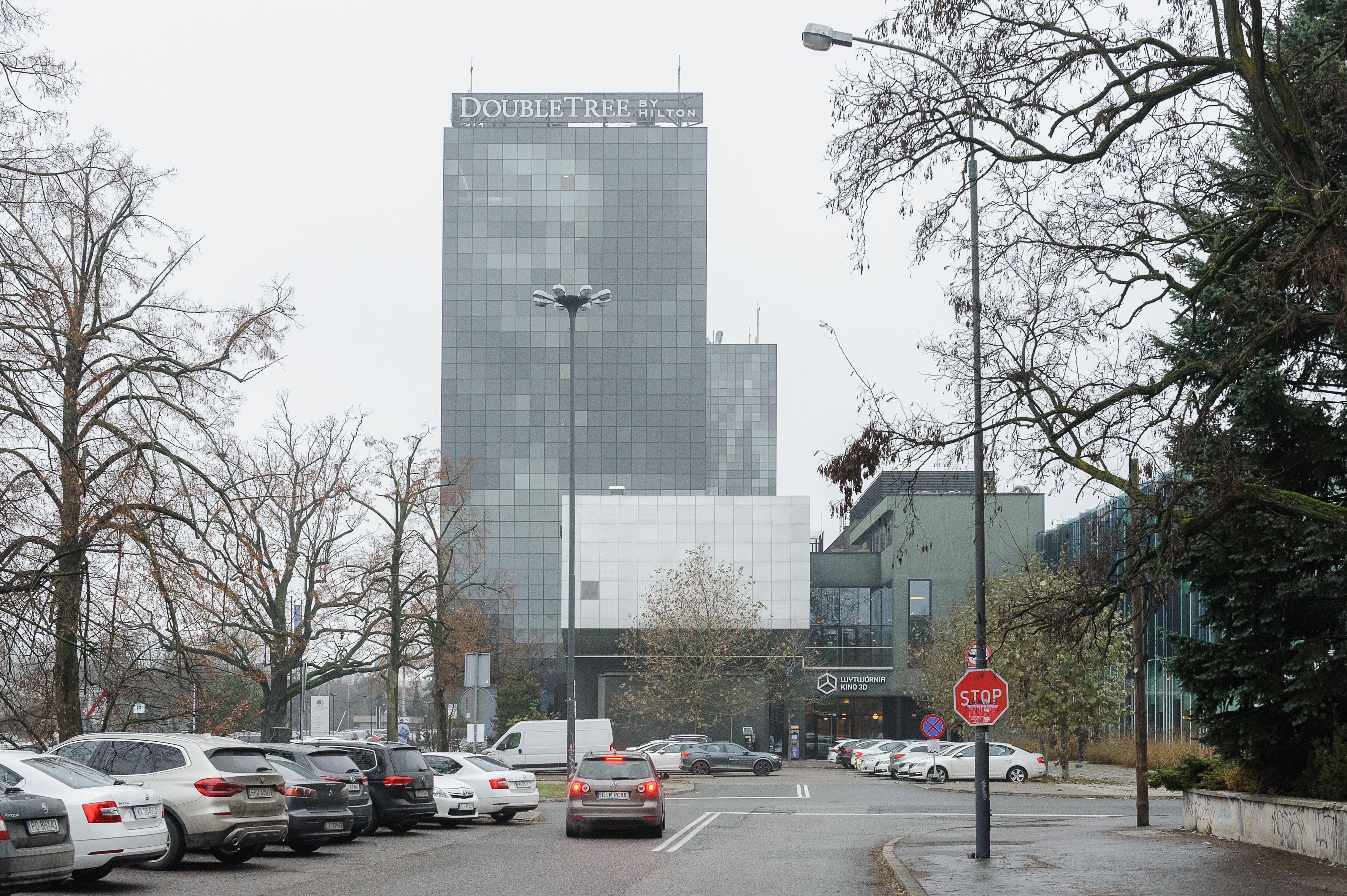 A parking lot with cars and a building with a sign that reads "DOUBLETREE BY HILTON".