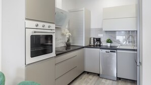 A modern kitchen with a built-in oven, dishwasher, and a coffee maker on the counter. - Lumina apart near Cinema Museum (Lodz)