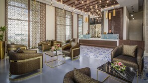 A modern lobby with patterned walls, a reception desk, and comfortable seating areas. - Central Inn Souq Waqif (Doha)