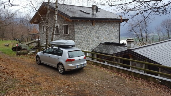 A stone house with a car parked in front. - Le Tartarughe (Montemezzo)