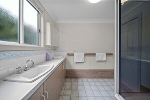 A bathroom with a sink, mirror, and wooden vanity.