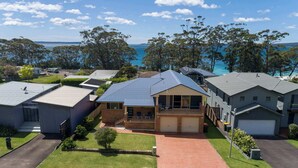 A residential area with houses, a driveway, and a view of the sea.