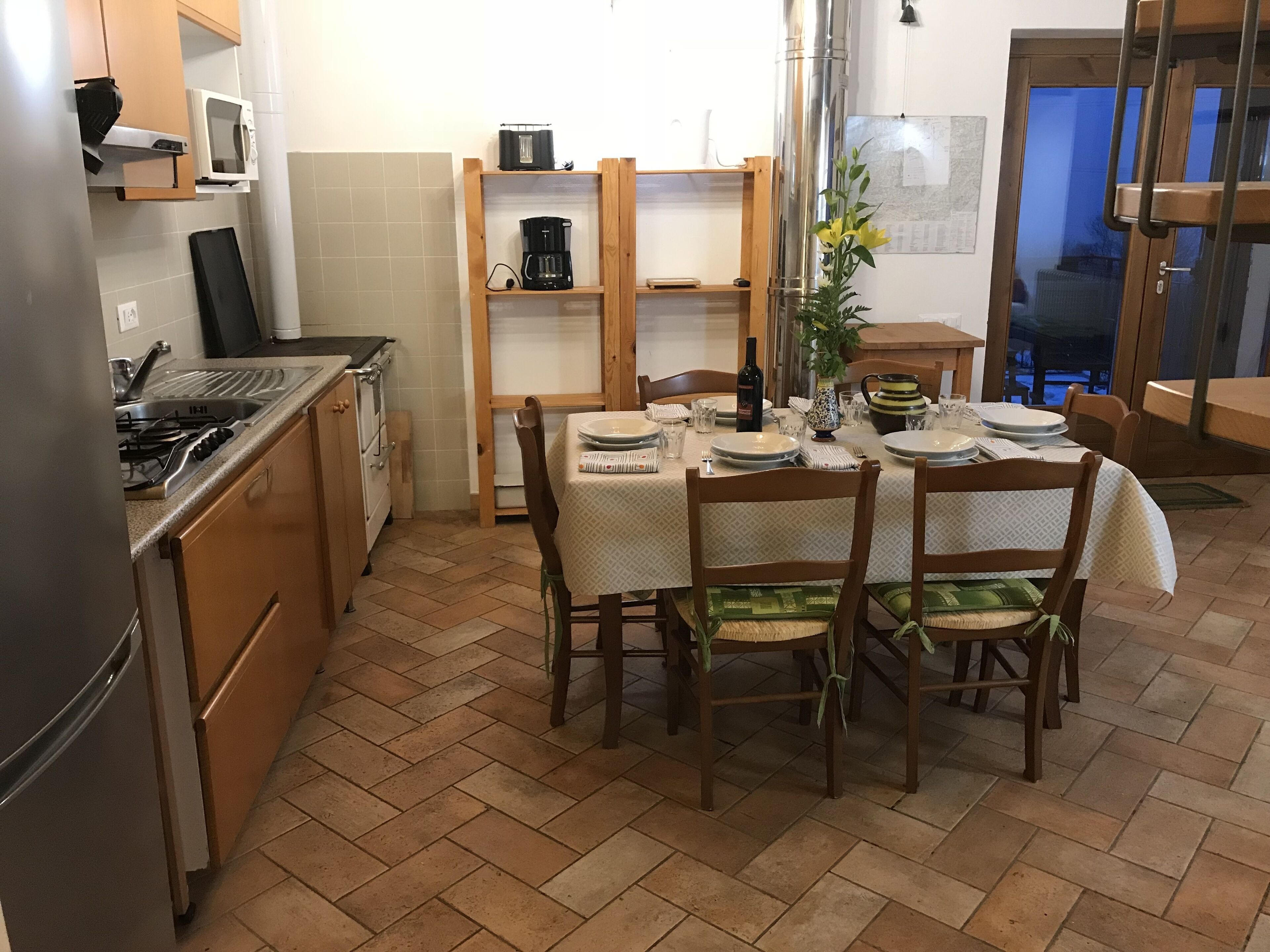 Ett kök med ett matbord för fyra personer, träskåp, en spis och en mikrovågsugn.