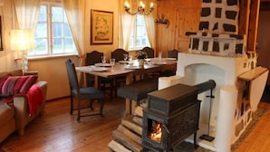 A cozy room with a fireplace, wooden furniture, and a dining table.