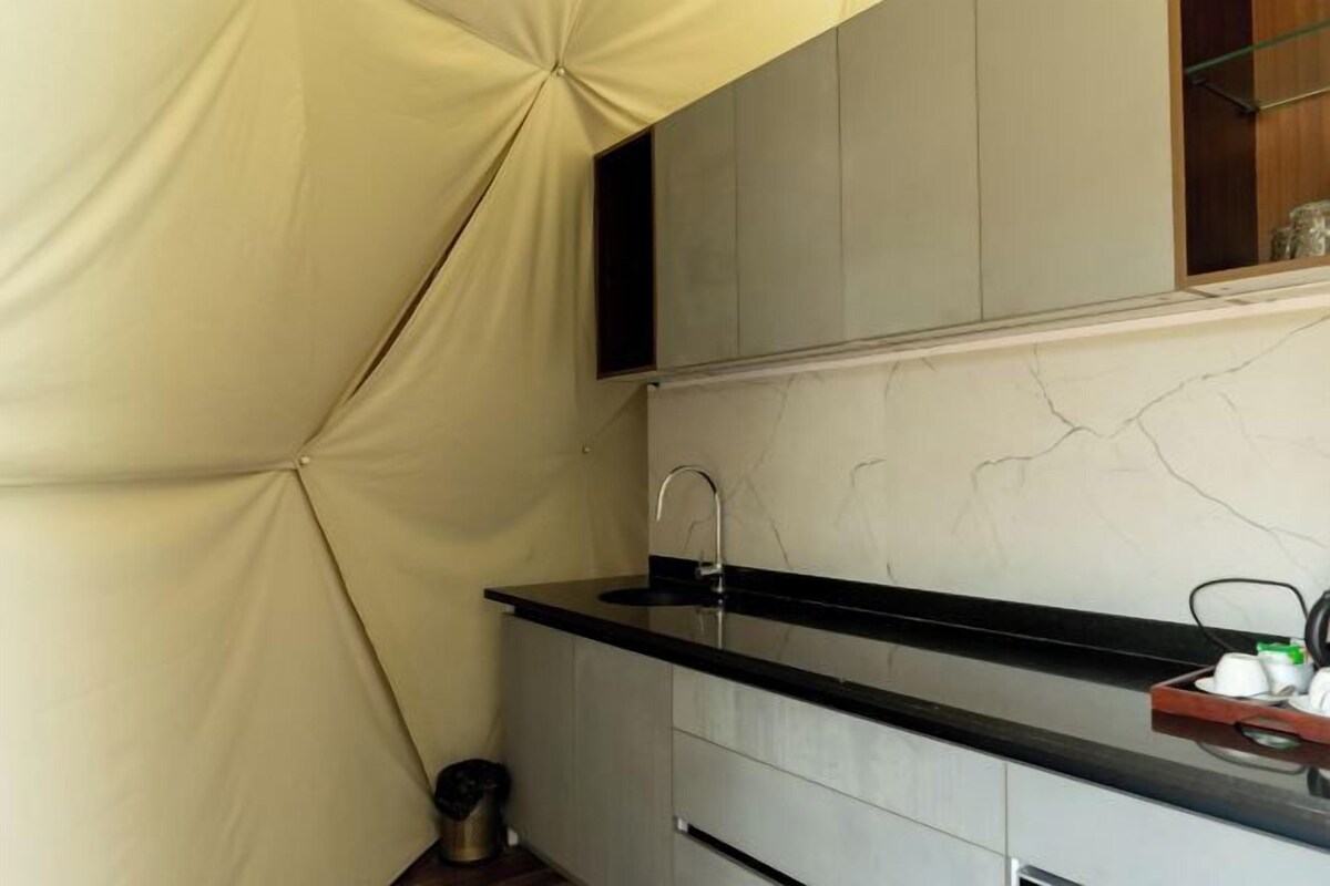A compact kitchen with a black countertop, a single sink, and a cabinet above.