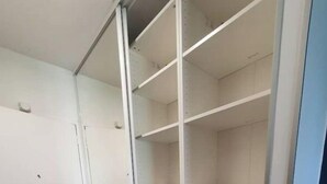 Un armario vestidor con repisas abiertas y una barra para colgar ropa.