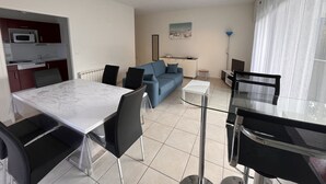 Un apartamento moderno con comedor, sala de estar con sofá y cocina.