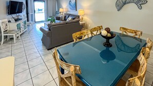 Un salón amplio con mesa de comedor, sillas, sofá y televisor.