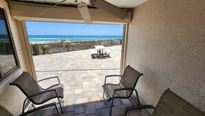 Un balcón con dos sillas, una mesa y vistas al océano.