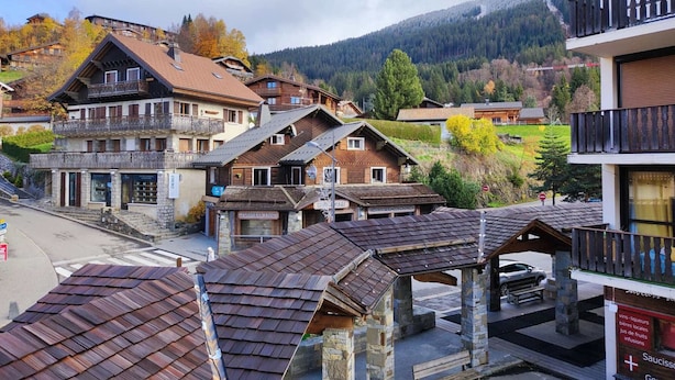 A traditional European village with wooden houses, a stone building, and a mountain backdrop. - Cozy Studio for 4 in Village Center, Near Slopes and Shops (Les Carroz d'Arâches)