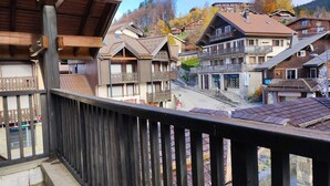 A traditional chalet-style building with a balcony, wooden railings, and a stone facade. - Cozy Studio for 4 in Village Center, Near Slopes and Shops (Les Carroz d'Arâches)