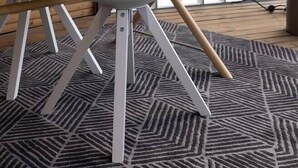 Une pièce moderne avec un plancher en bois, une chaise blanche aux pieds en bois, une table blanche et une plante en pot.