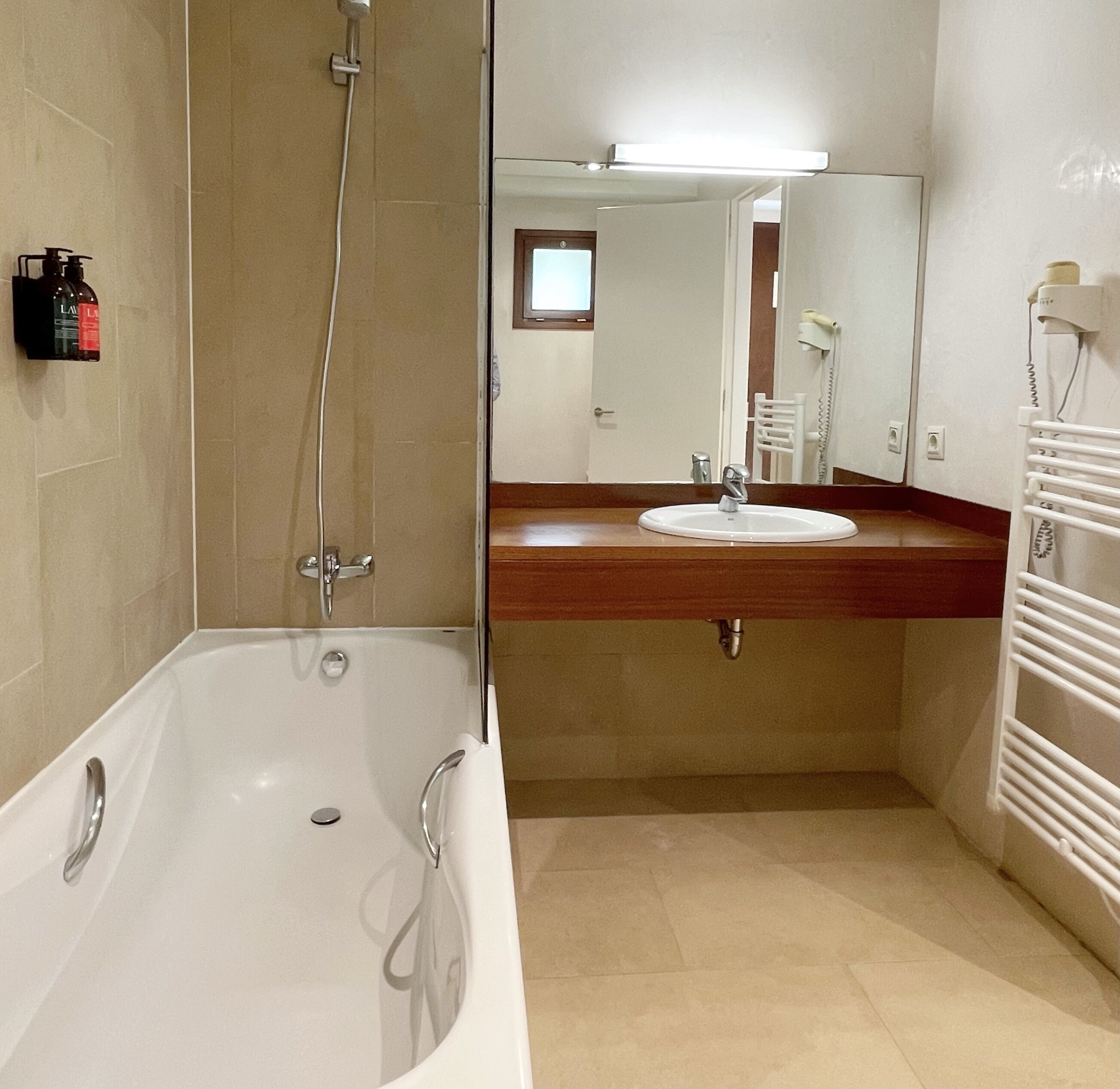 Un baño con bañera, lavamanos y espejo.
