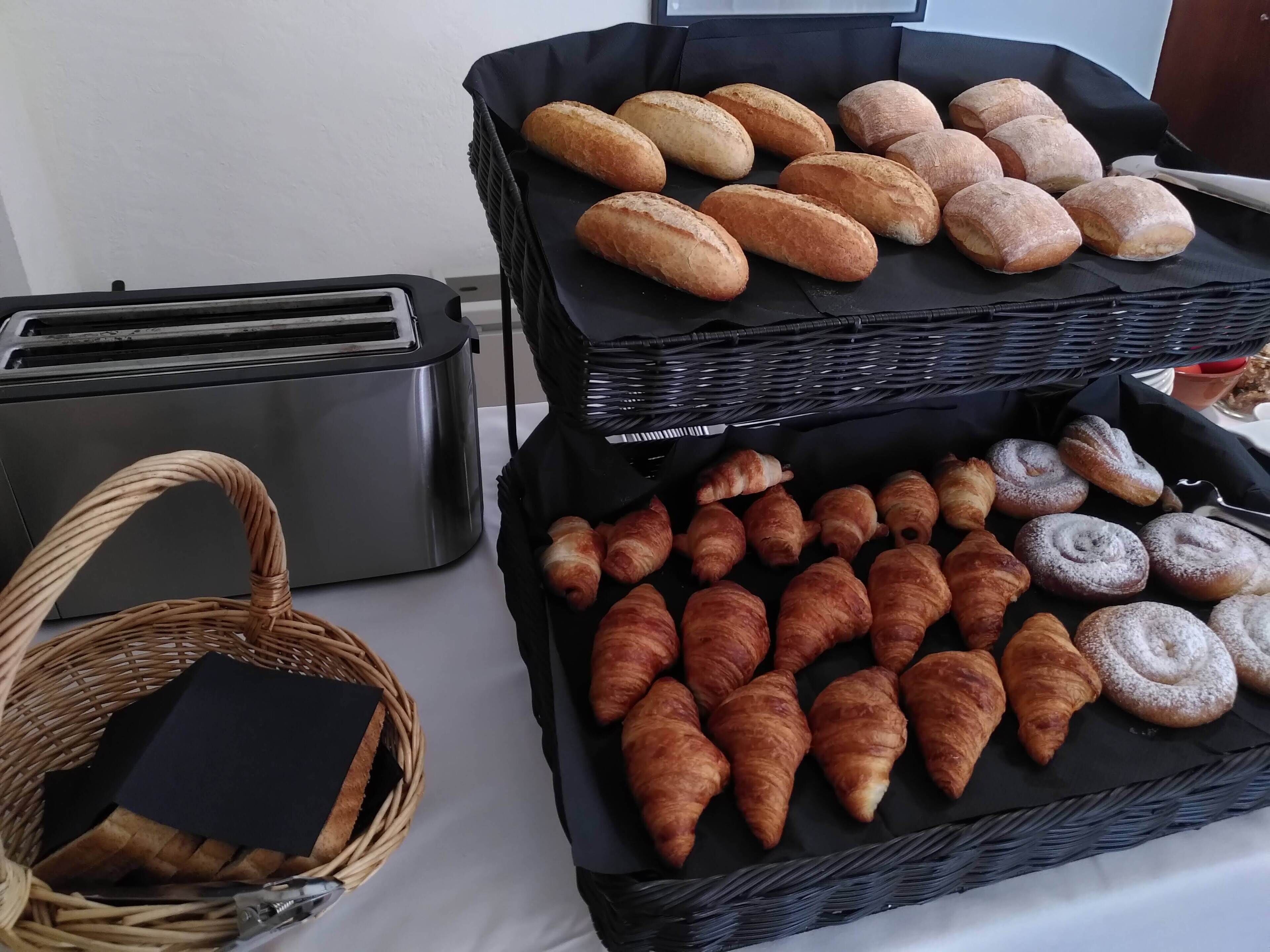 Una encimera de cocina con dos cestas de pan y un tostador.
