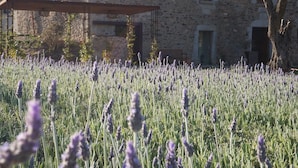 Un edificio de piedra con un balcón que da a un campo de lavanda.