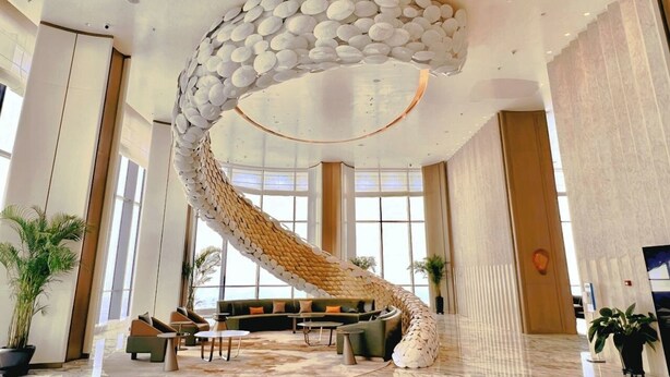 Un hall amplio con un diseño espiral único en el techo, una zona de estar confortable y grandes ventanales que dejan entrar luz natural.