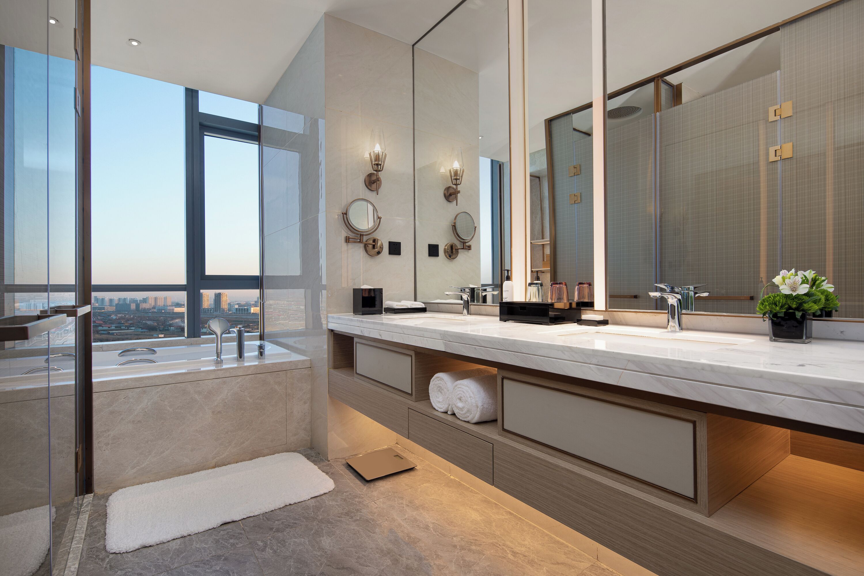 Une salle de bain moderne avec un grand miroir, un lavabo intégré et une vue sur la ville.