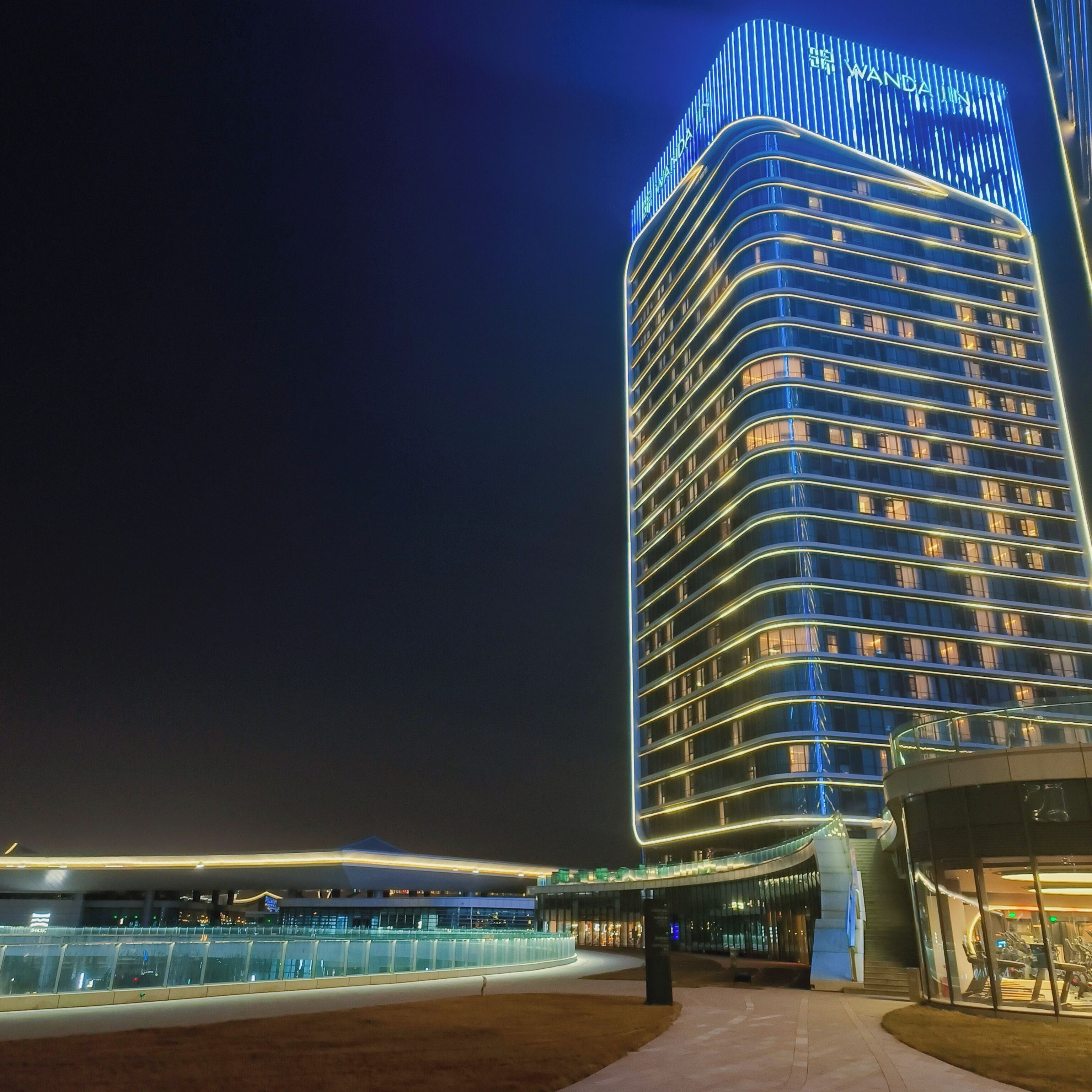 A high-rise hotel with a curved facade and illuminated signage.