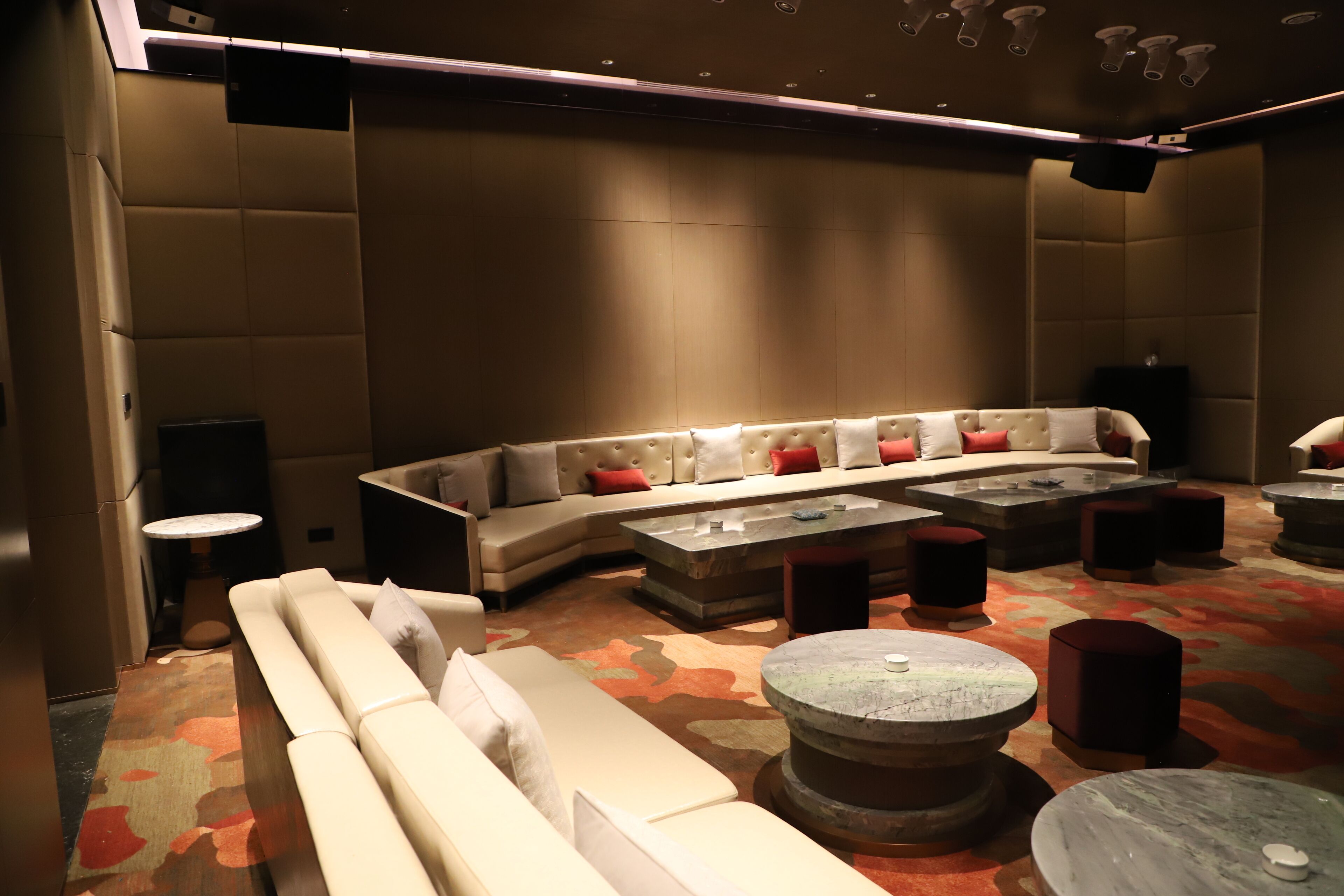 Un espace de détente moderne avec un canapé incurvé, de nombreux sièges et un tapis à motifs.