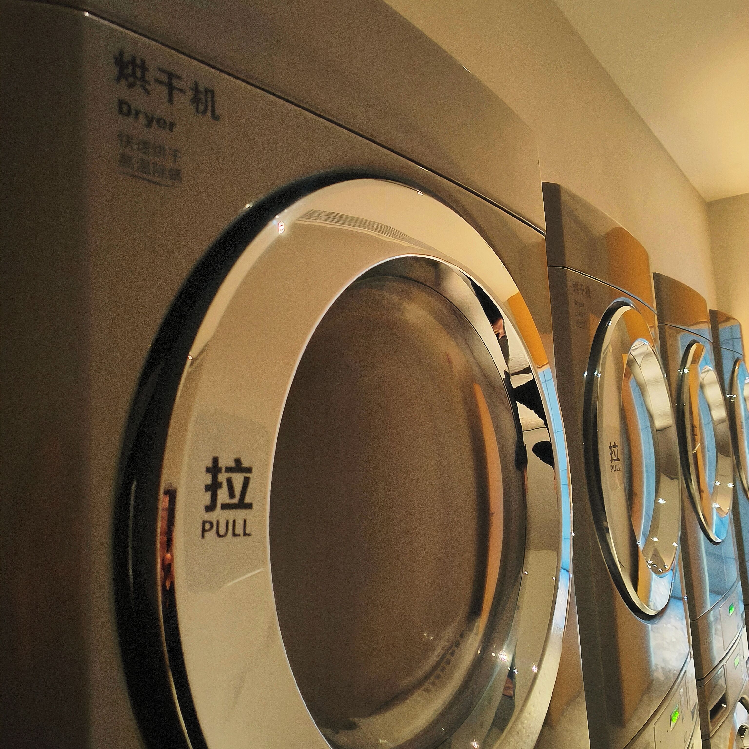 A row of front-loading washing machines with a "PULL" label on the door.