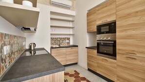 Een moderne keuken met houten kastjes, een ingebouwde oven en een magnetron.