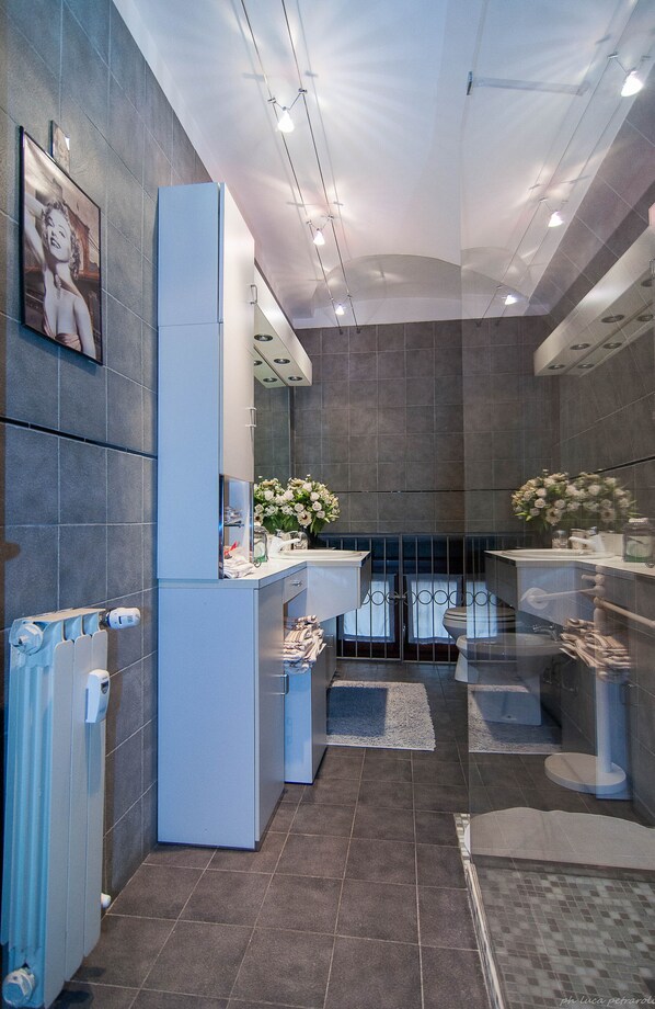 Une salle de bain moderne avec un grand miroir, deux lavabos et des toilettes.