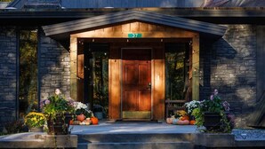 A stone building with a wooden front door, number 37, and a small porch with potted plants.