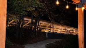 A pathway leading to a building with string lights and a covered area.