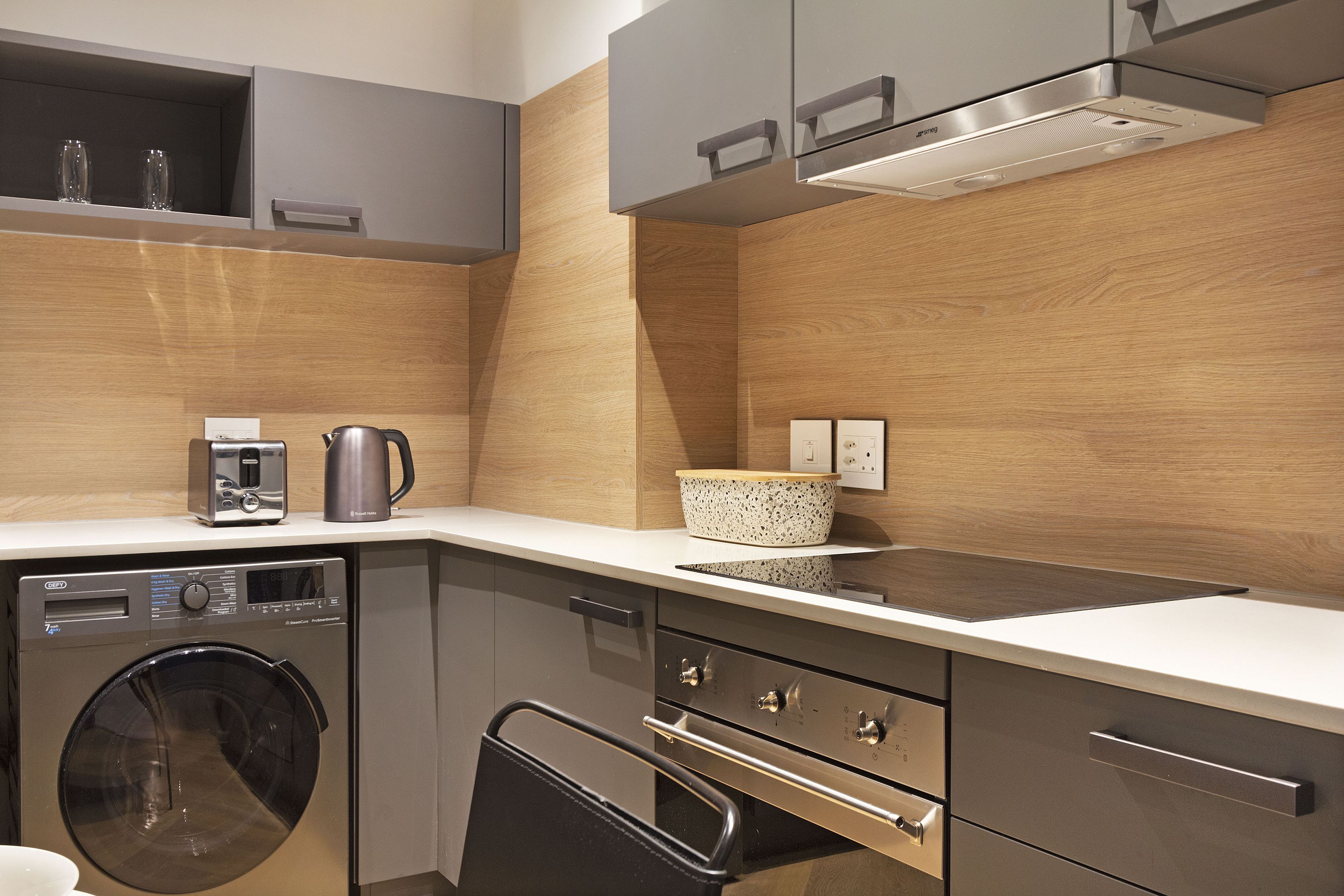 A modern kitchen with a built-in washer, oven, and microwave.