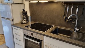 A compact kitchen with a built-in oven, a stovetop, and a sink.