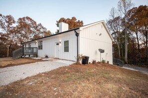 A single-story building with a white exterior, a covered porch, and a satellite dish.