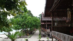 A beachside walkway with wooden structures and potted plants. - marine homestay (Pulau Fam)