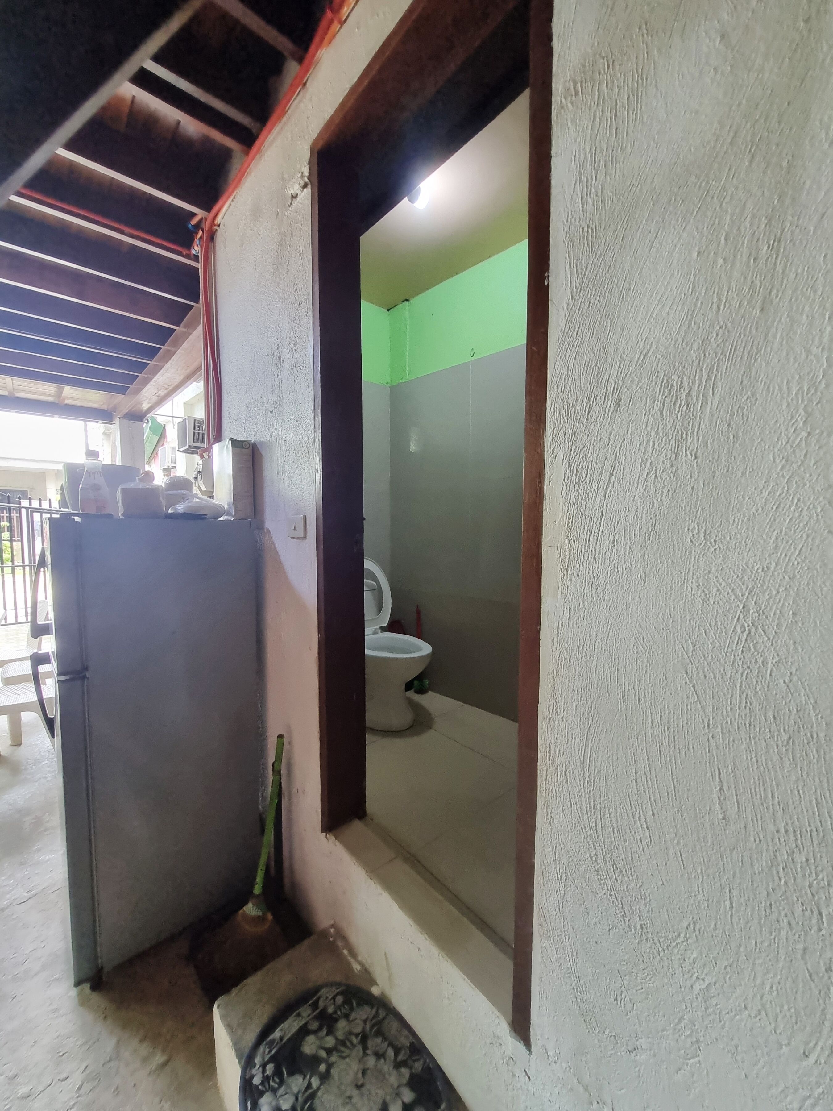 A small, enclosed bathroom with a toilet and a sink.