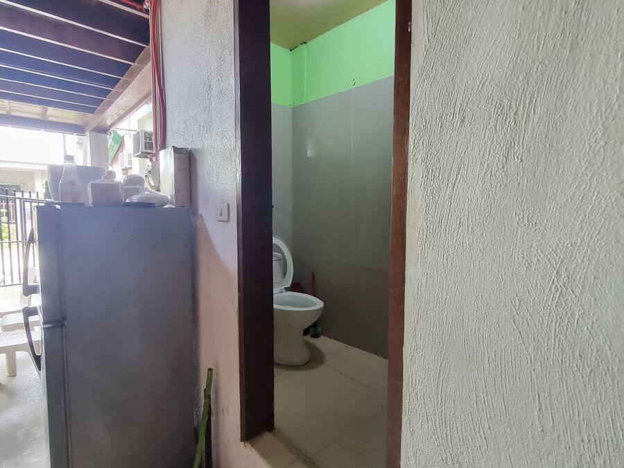 Un baño pequeño y cerrado con inodoro y lavamanos.