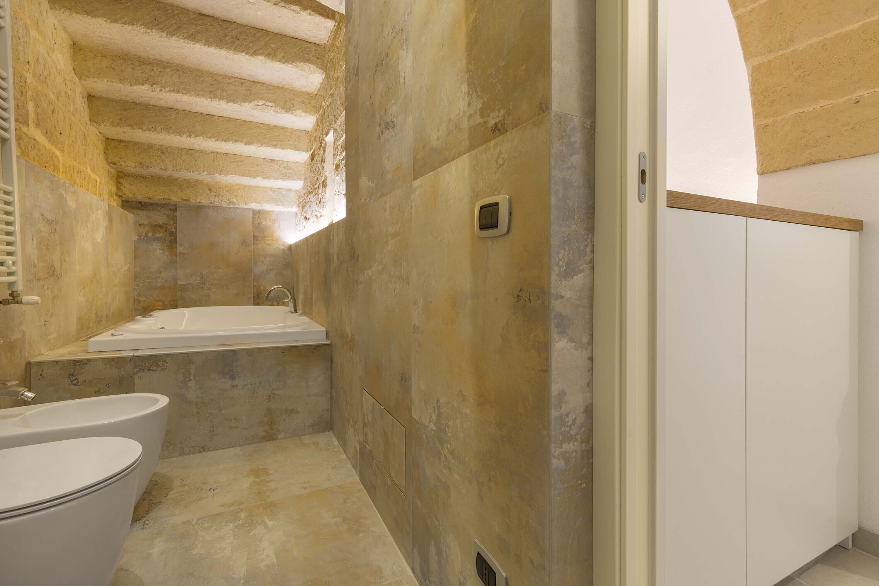 A bathroom with a bathtub, toilet, and a shower area.