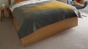 Un dormitorio con cama, un mapa en la pared, una silla y una ventana.