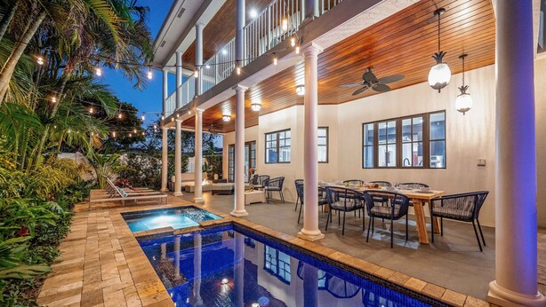 A poolside area with a pool, outdoor seating, and a covered patio with chairs and tables. - Walk to Beach / Heated Pool / Serenity at its Finest / Hemingway Key / VlLLAS (Fort Lauderdale)