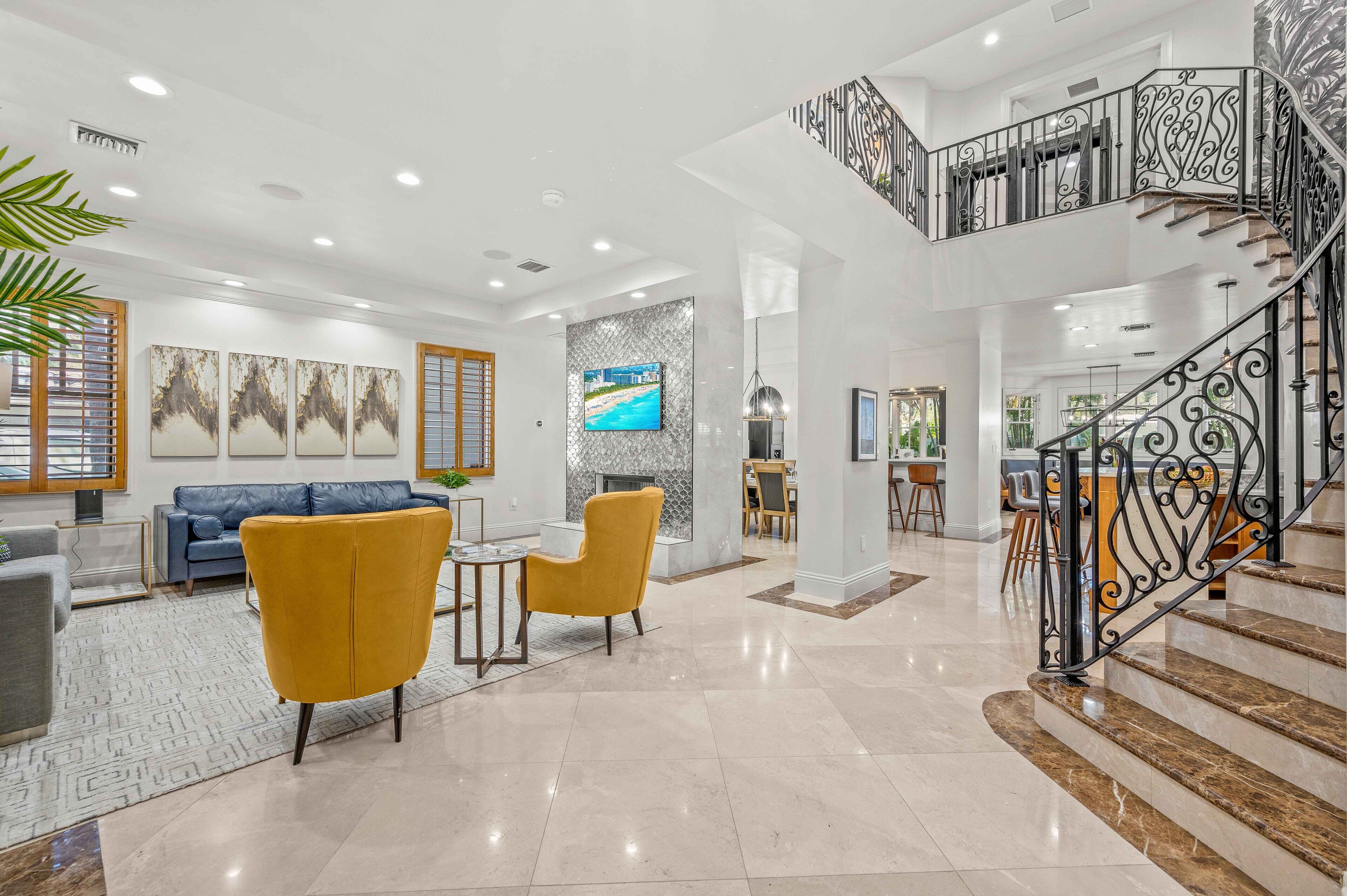 A spacious living area with a modern staircase, a sofa, and a TV.