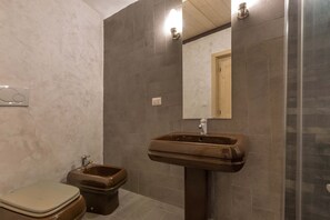 A bathroom with a toilet, bidet, and sink.
