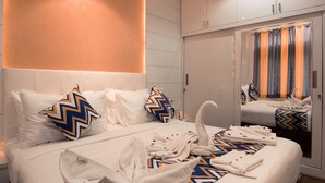 Et hotelværelse med en stor seng, to puder, en badekåbe og et spejl.