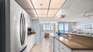 Una cocina moderna con una isla grande, electrodomésticos de acero inoxidable y vistas al océano.