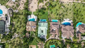 Luftaufnahme eines Resorts mit mehreren Gebäuden, einem Strand und einem Poolbereich.