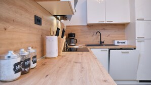 Una cucina moderna con piani di lavoro in legno, pensili bianchi e una macchina per caffè.