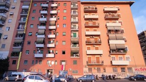 A multi-story residential building with balconies, air conditioning units, and a gated entrance. - Camesena 40 | 2BR Apartment for 4 with Balcony near Tiburtina (Roma)
