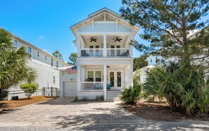 A two-story house with a front porch, a garage, and a mailbox.